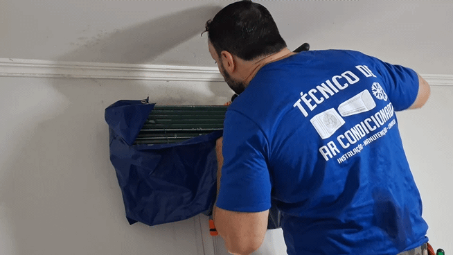Técnico realizando higienização da evaporadora com proteção para o ambiente